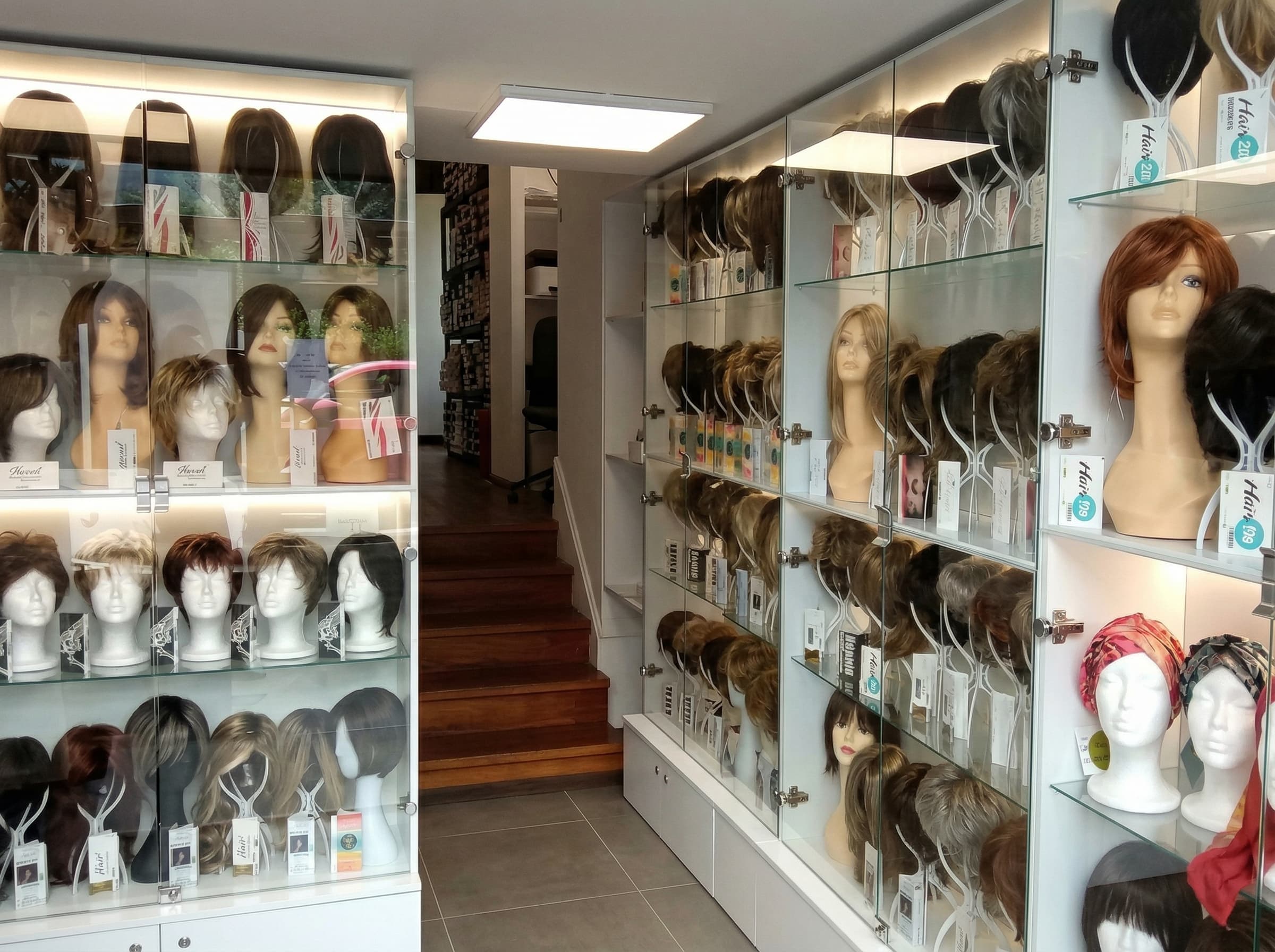 Z&nbsp;bliska uchwycone podświetlane gabloty w&nbsp;częstochowskim salonie Rokoko, w&nbsp;których na&nbsp;głowach manekinów wyeksponowano zróżnicowane peruki damskie.