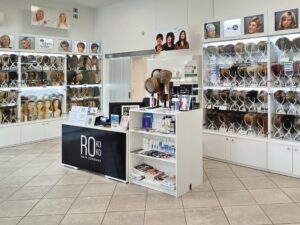 Salon Rokoko Białystok — lada z logo i gabloty z perukami Tytuł: Peruki Białystok — salon i sklep Rokoko Hair Company